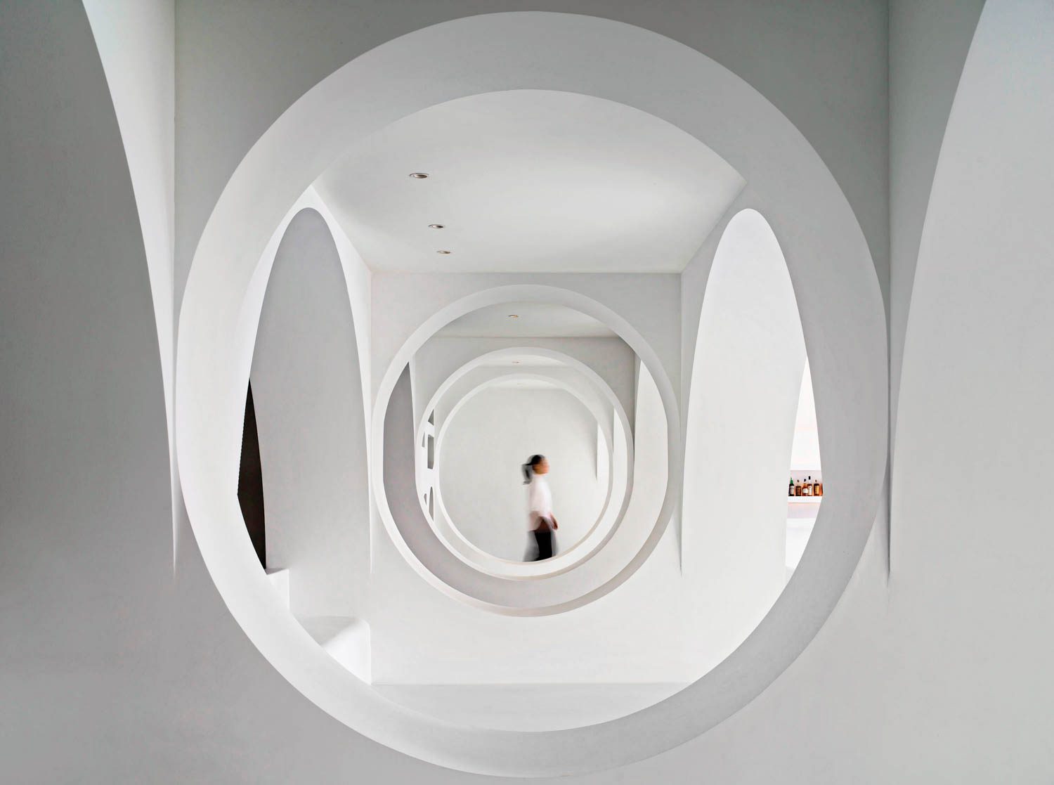 circular cutouts highlighting a person walking through the hotel