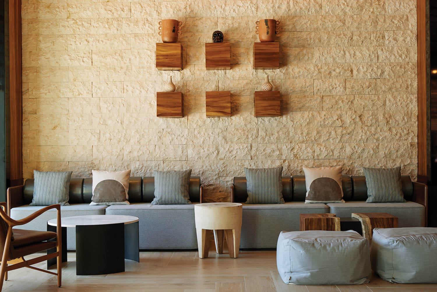 a lobby area with blue sofas and wood crafts on the wall