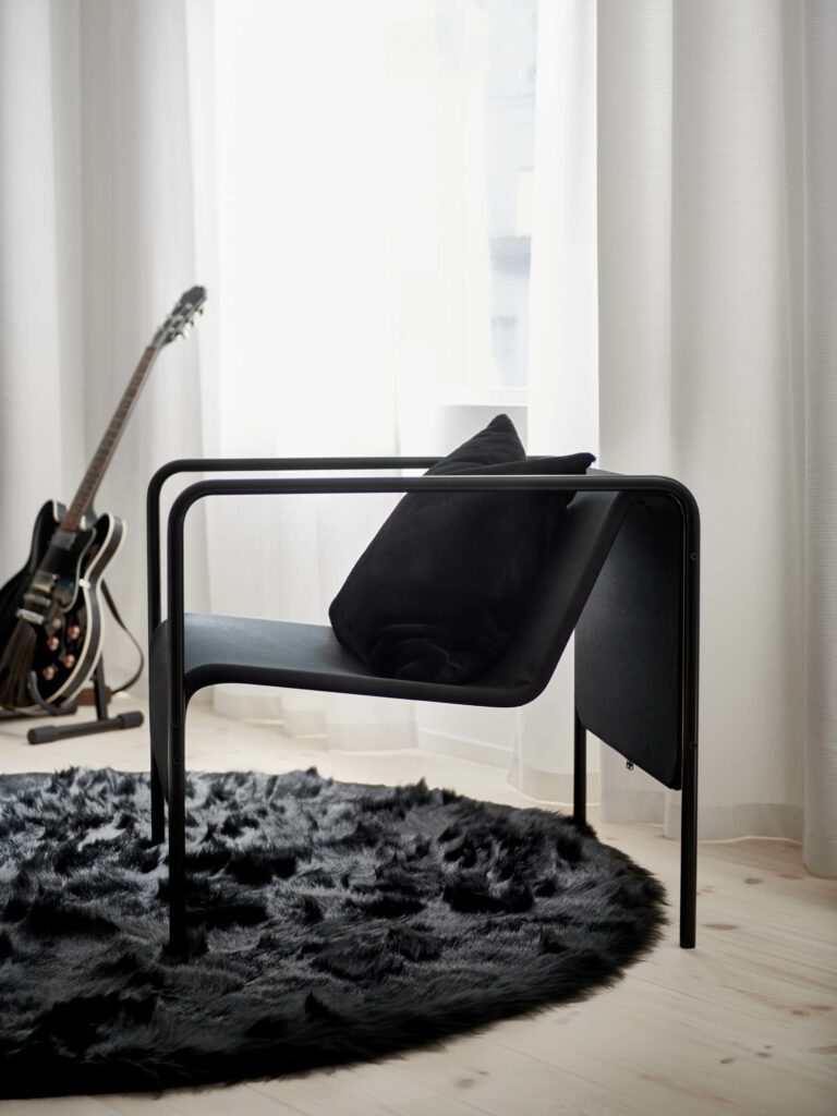 A guitar rests behind one of the Swedish House Mafia x IKEA chairs.