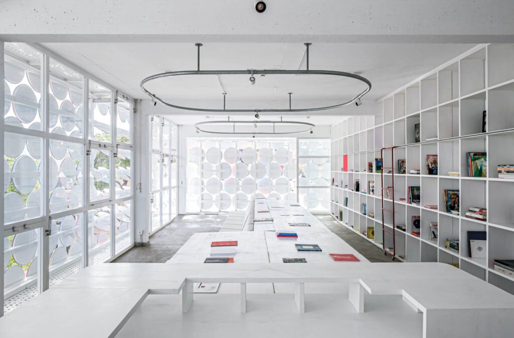 a library with built in shelves and a view of the painted lids out the window