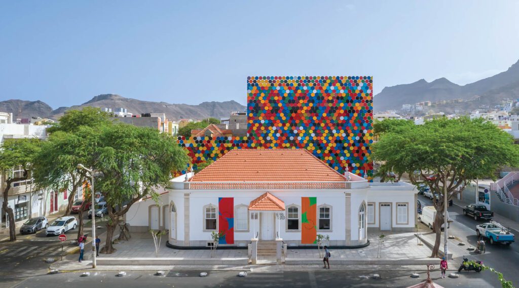 a colonial-era house with painted steel lids behind it