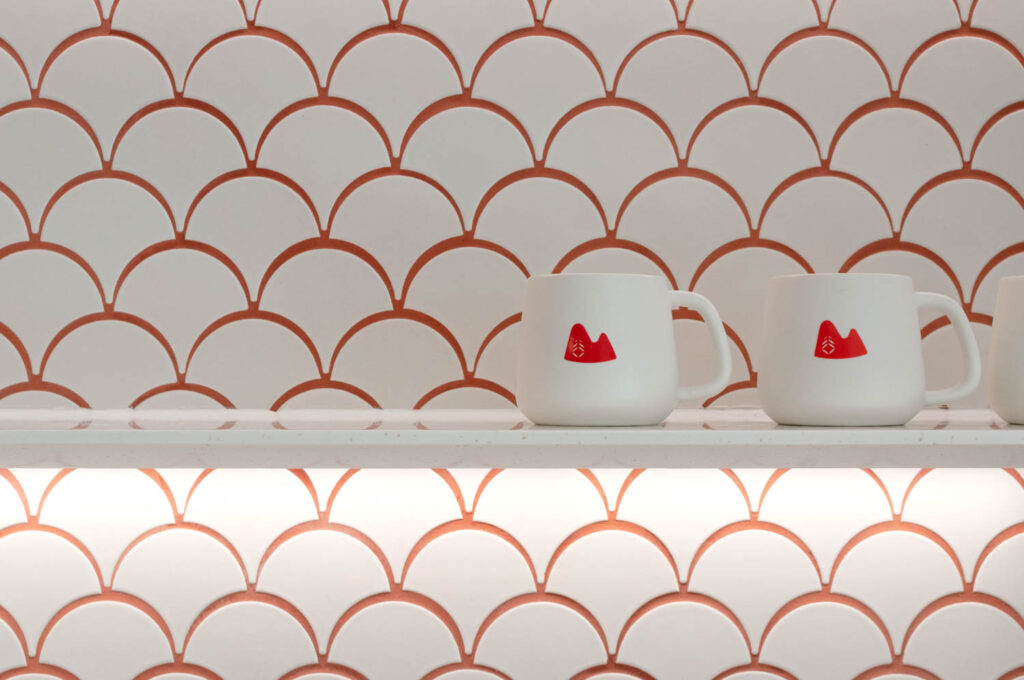 a pantry tile wall with white curved tiles accented by red grout