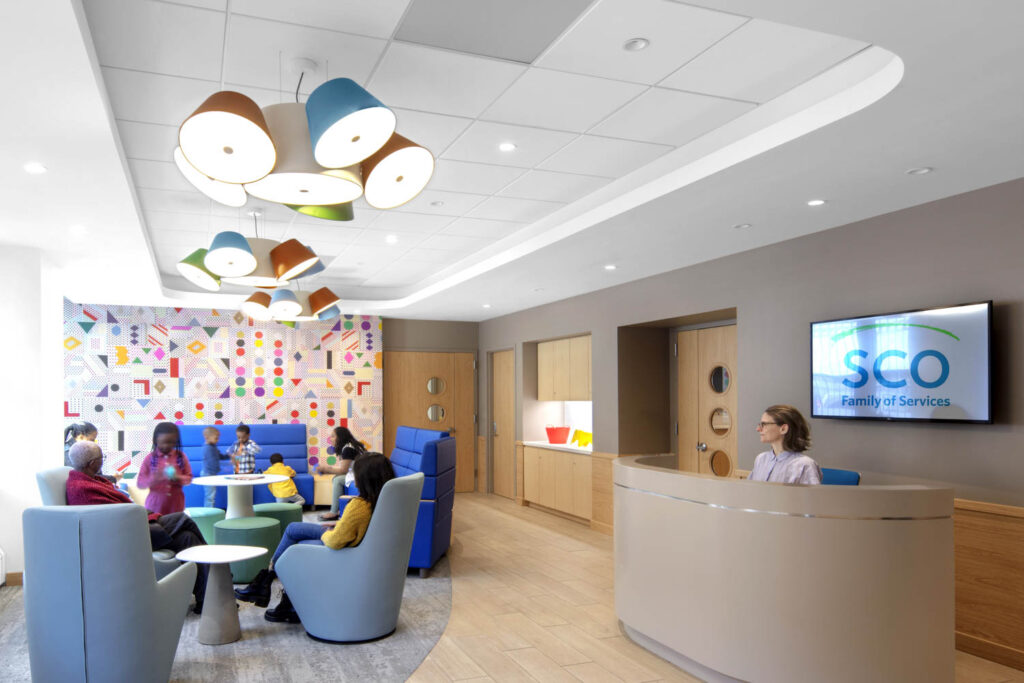 a reception area with a colorful wall and lounge seating