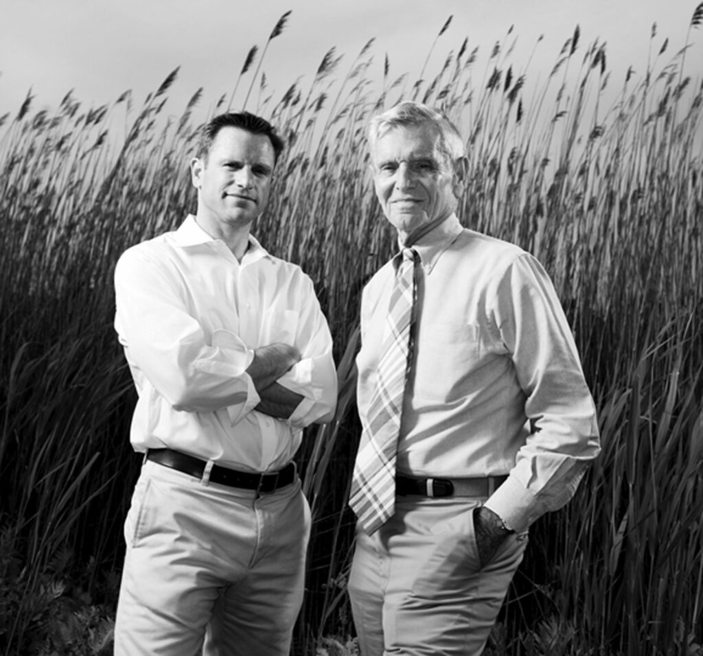 Paul Masi and Harry Bates standing in a field of wheat. 