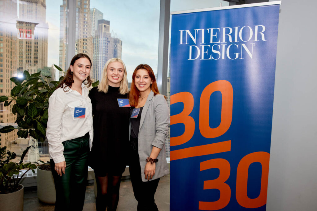 Three young designers stand in front of Interior Design's 30/30 sign.