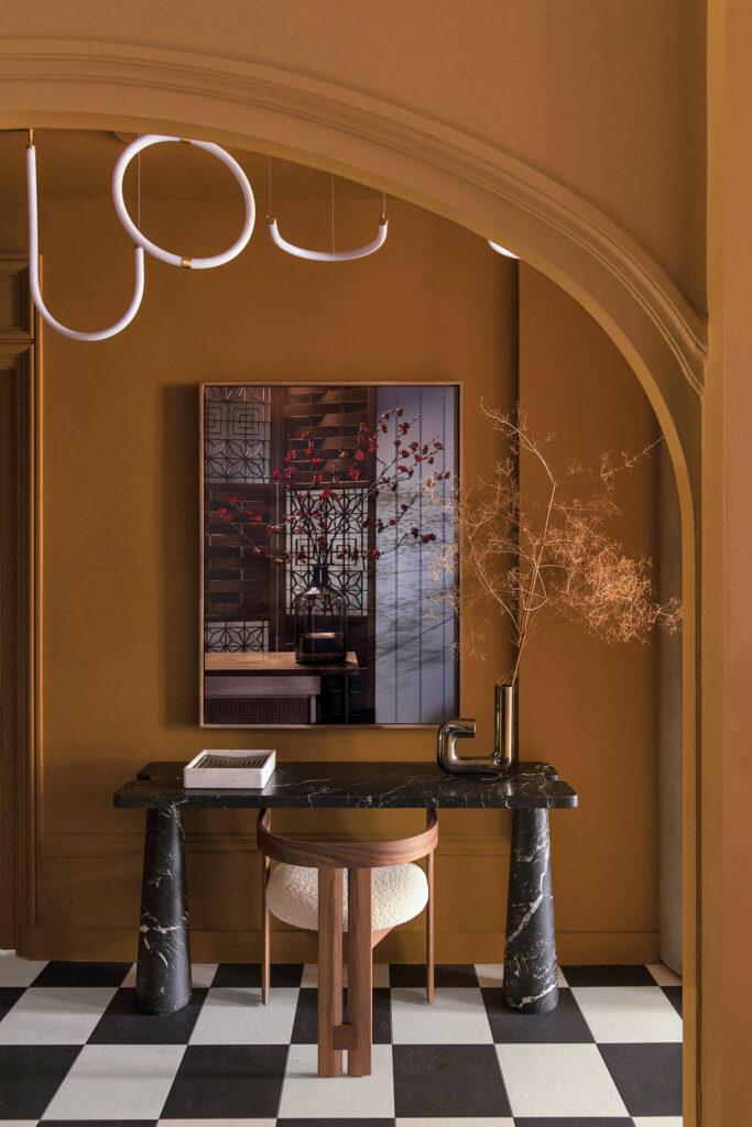 a niche off the entryway of a French apartment with a marble desk