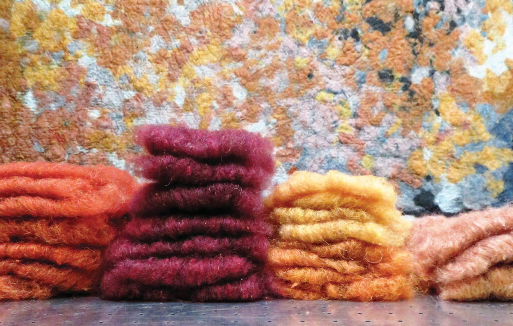 a palette of carded, naturally dyed fibers in orange, red, yellow and pink