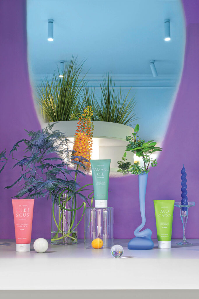 greenery and flowers surround a cosmetics display