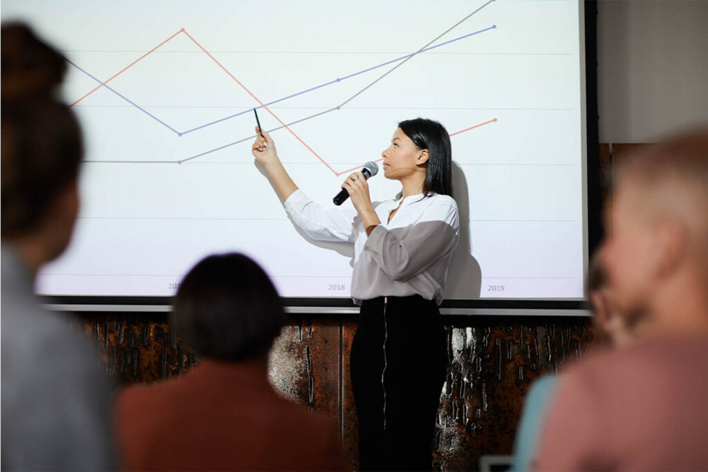 a woman pointing at a chart