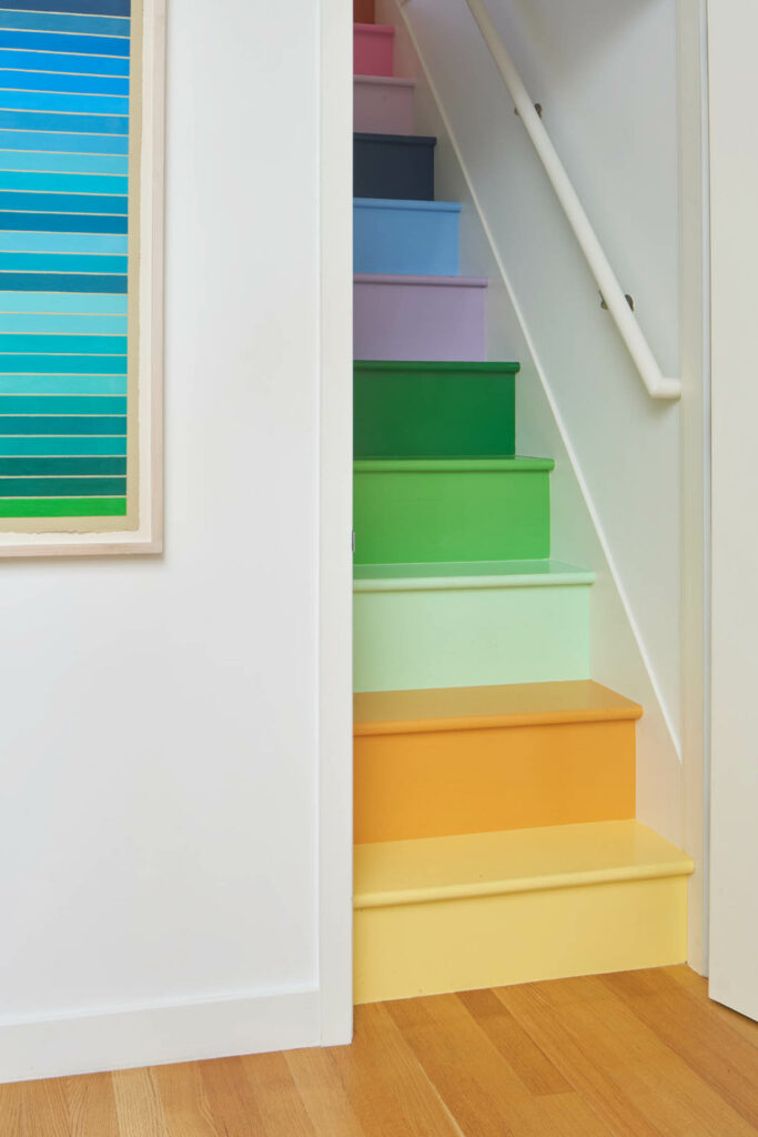 Rainbow steps add pops of color to this narrow stairway.