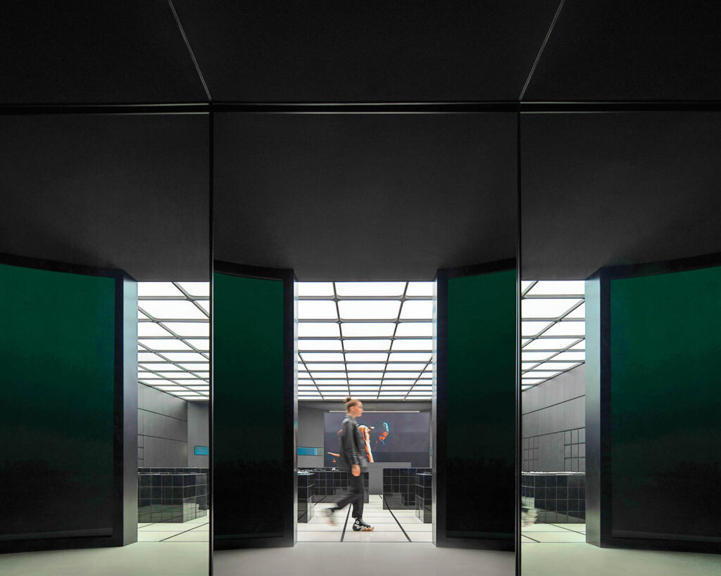 A woman walks near black columns in KVK's new showroom in China