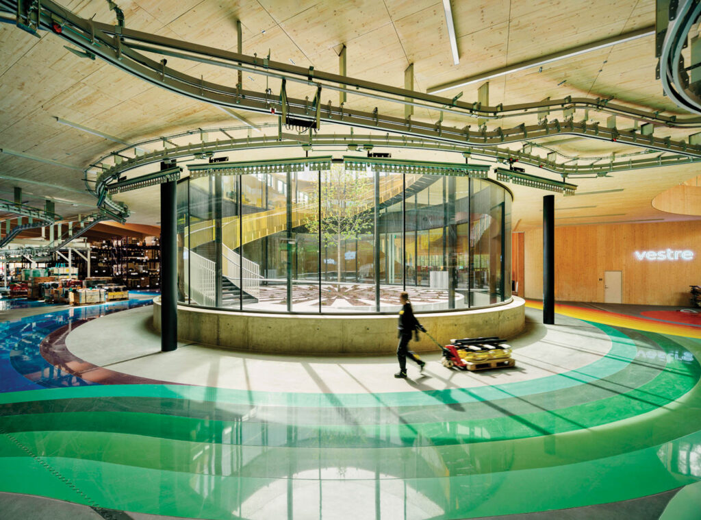 a glass circle sits in the center of a room with shiny blue and green floors