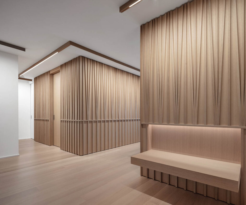 milled oak covers the walls in this apartment, matching the light hardwood floors