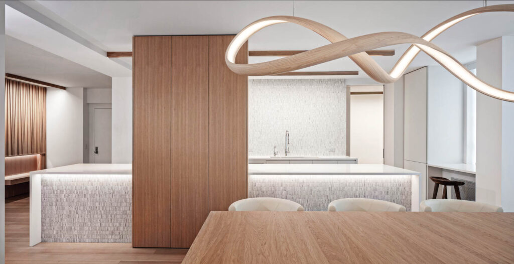 a curving sculptural light fixture hangs above a dining room table