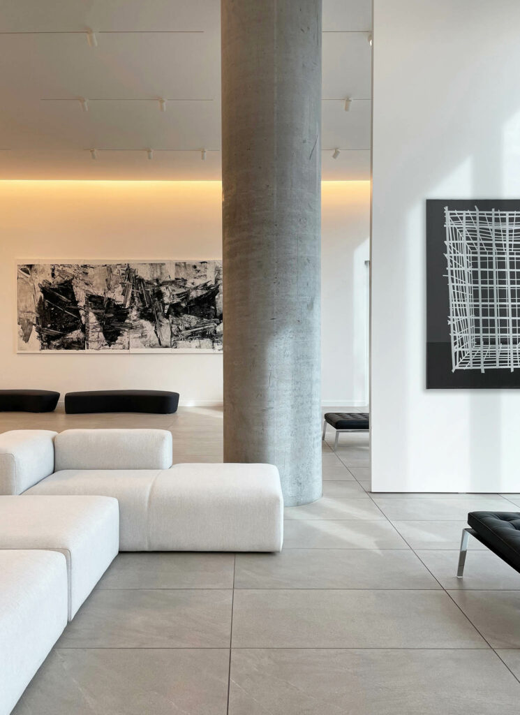 a seating area with a sofa and black and white artwork on the walls