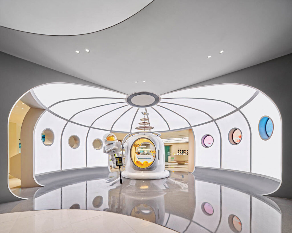 White walls seem to curve upward with each section housing a small porthole in various pastel hues