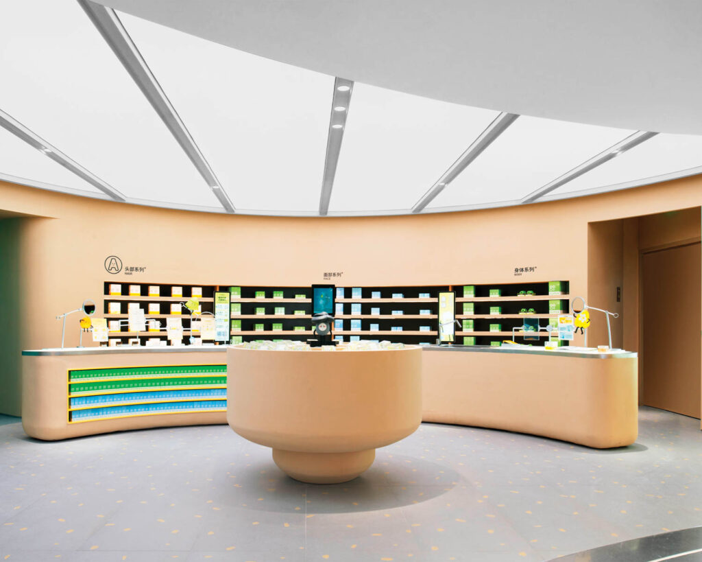 A tan wall with brightly colored product boxes shelved within and a cosmetics counters that snakes around in front