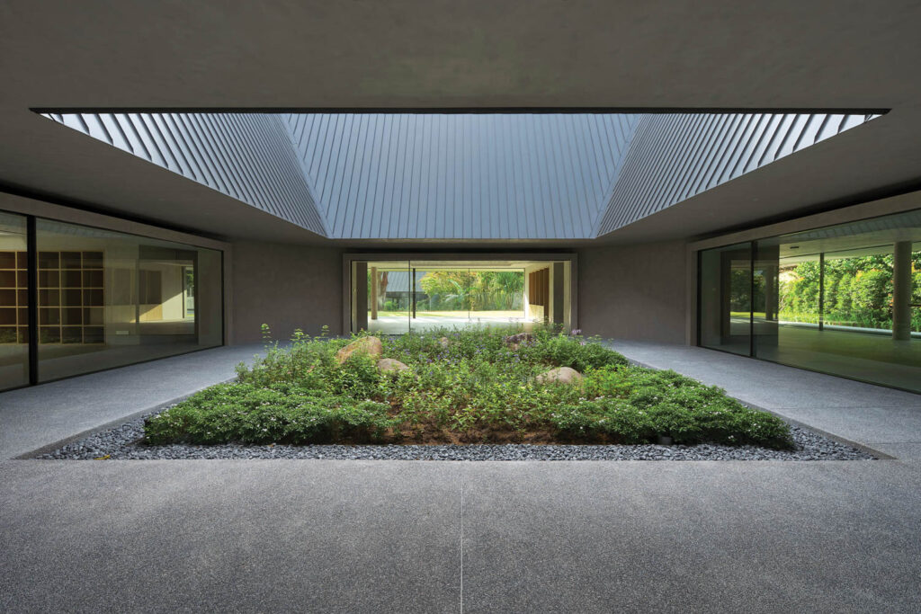 The interior courtyard centers the space with its mossy garden surrounded by a sea of gray.