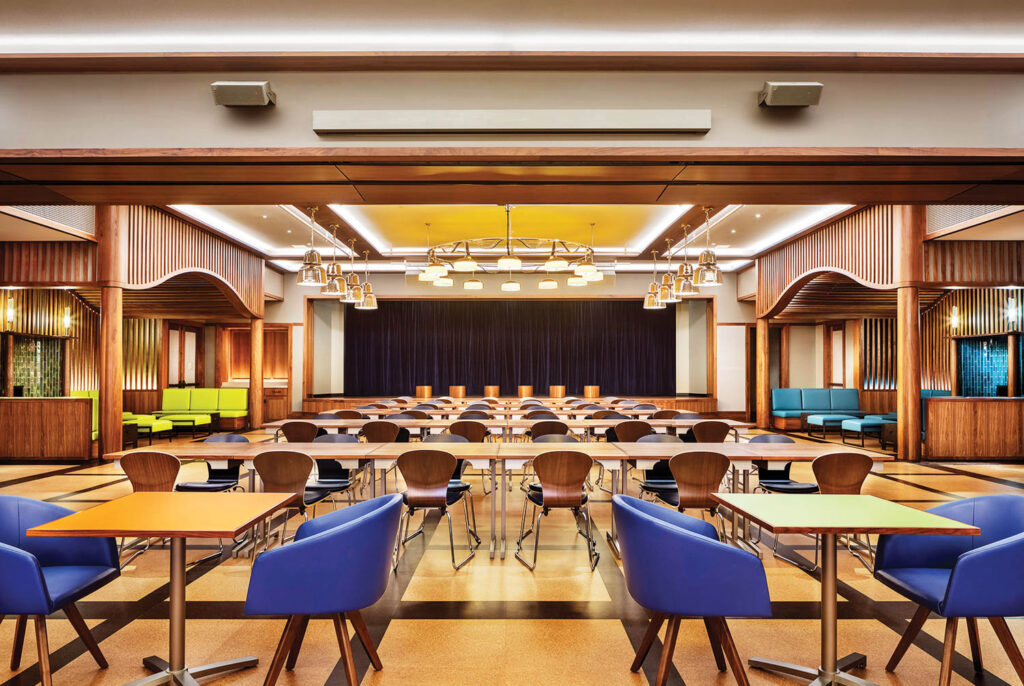 blue dining chairs behind long banquette tables