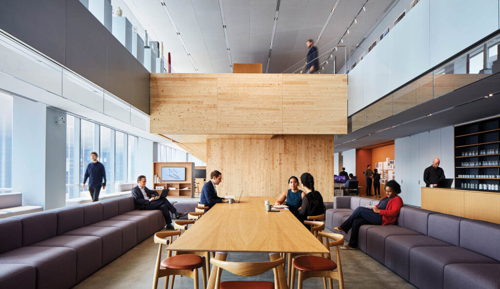 people work at a conference table in an open office