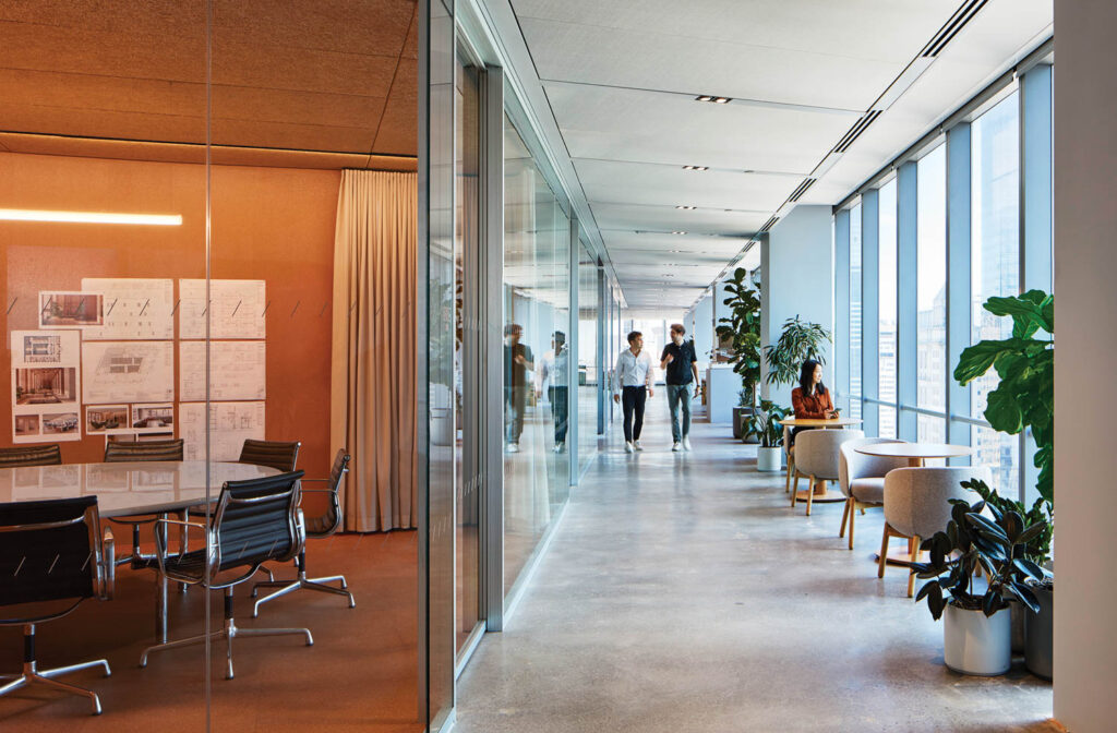 people walk down the hall toward a conference room in an office