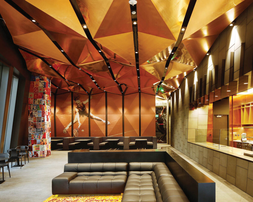 A black leather couch at the Nike World Headquarters beneath a ceiling of orange-hued panels.