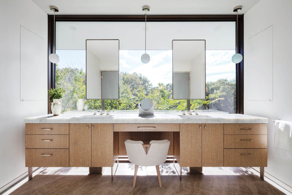 a dual vanity in front of a windowed wall 