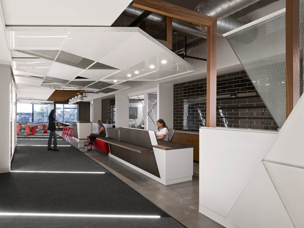 a reception desk in a lobby with white walls and flooring with embedded lighting