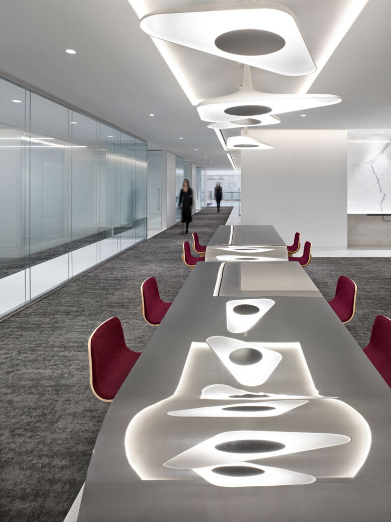 organic shapes light up a conference table with maroon chairs