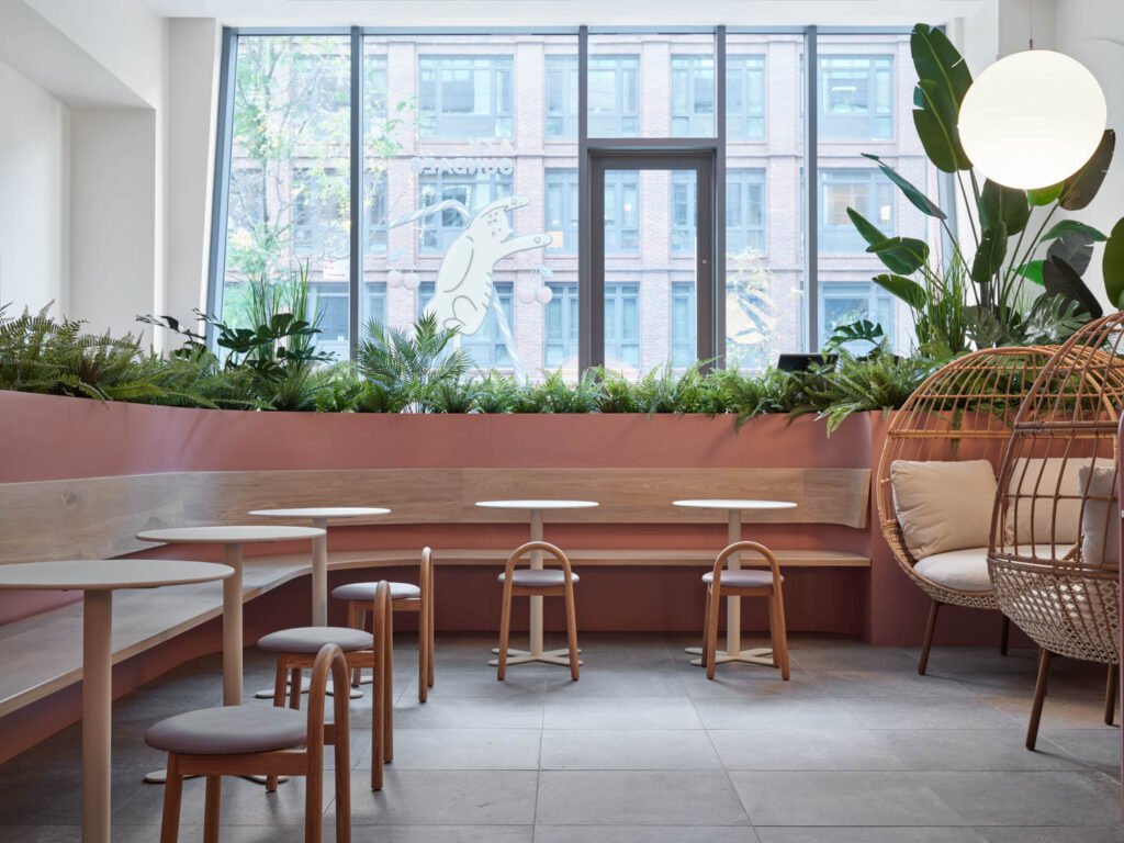 A bench curves around the cafe with small circular tables and stools near the front window. 