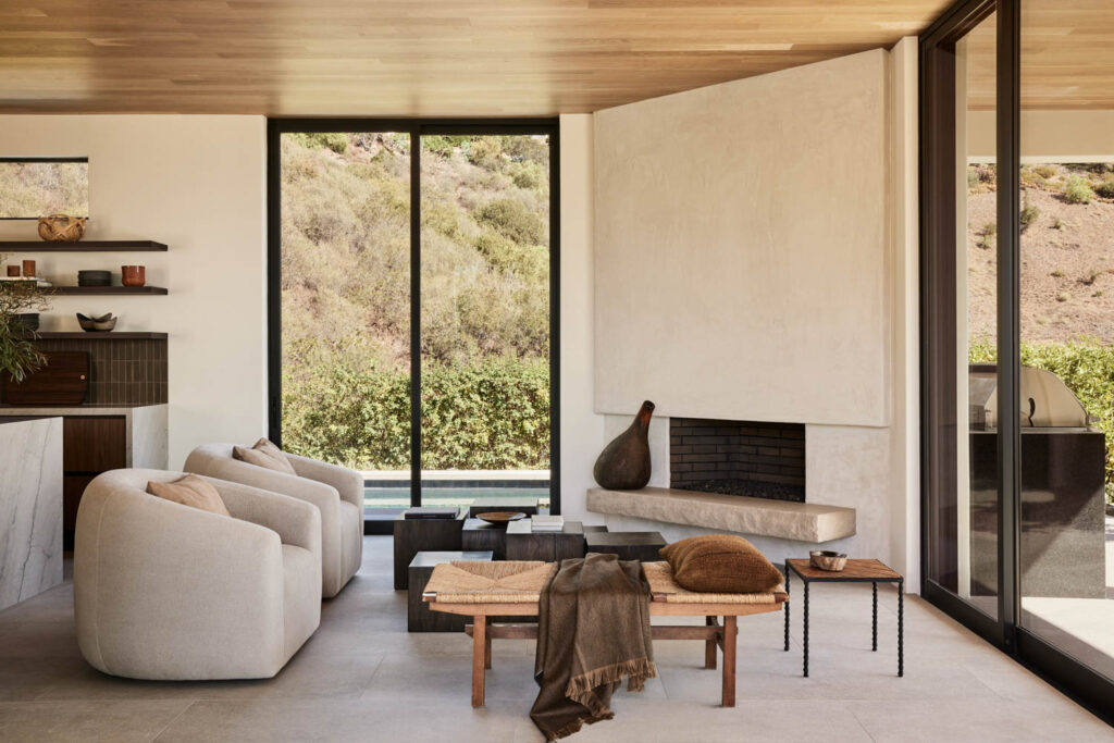 a living room with a fireplace and large windows