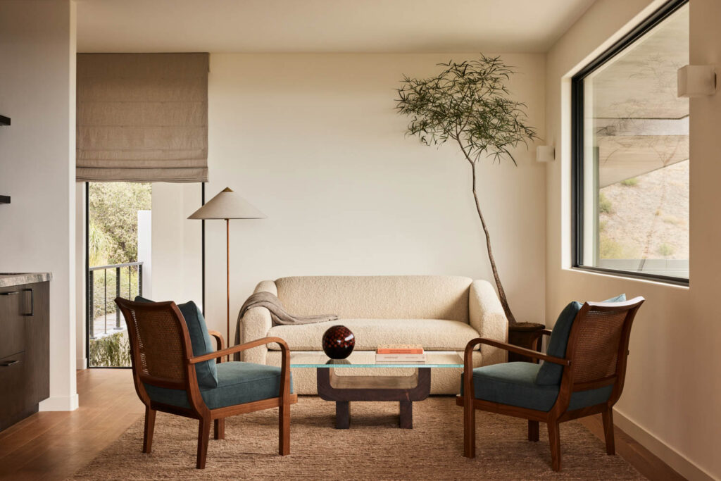 a seating area in a bedroom with sofa and arm chairs