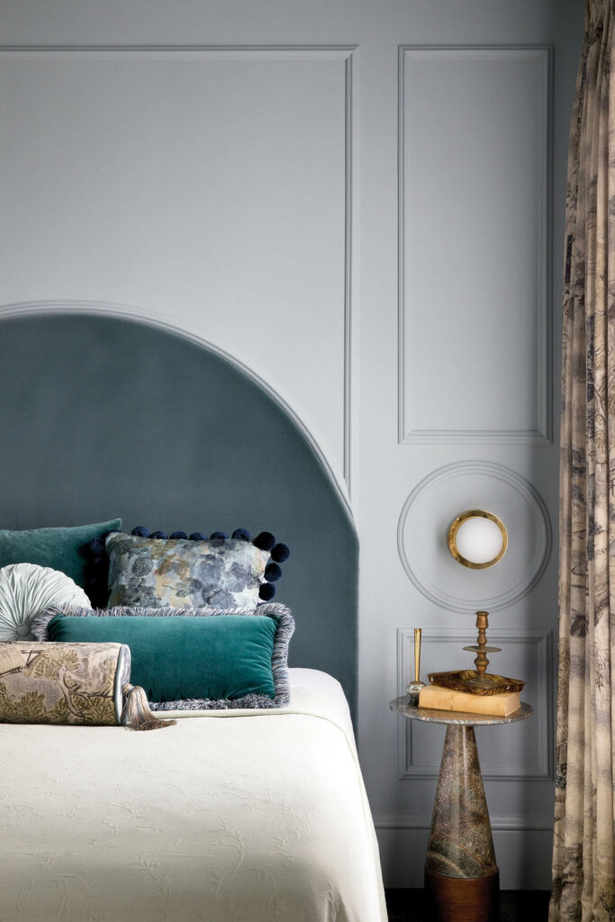 a marble table next to a bed in shades of teal