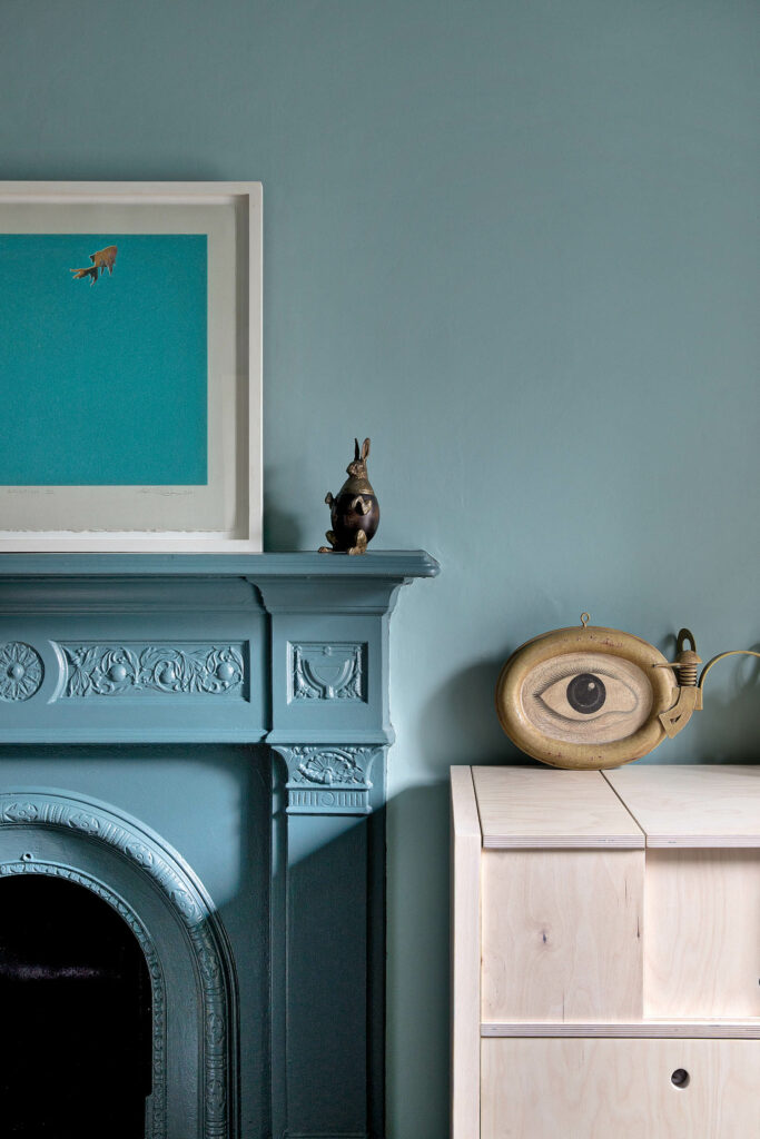 a fireplace with blue mantle matching the wall next to it 