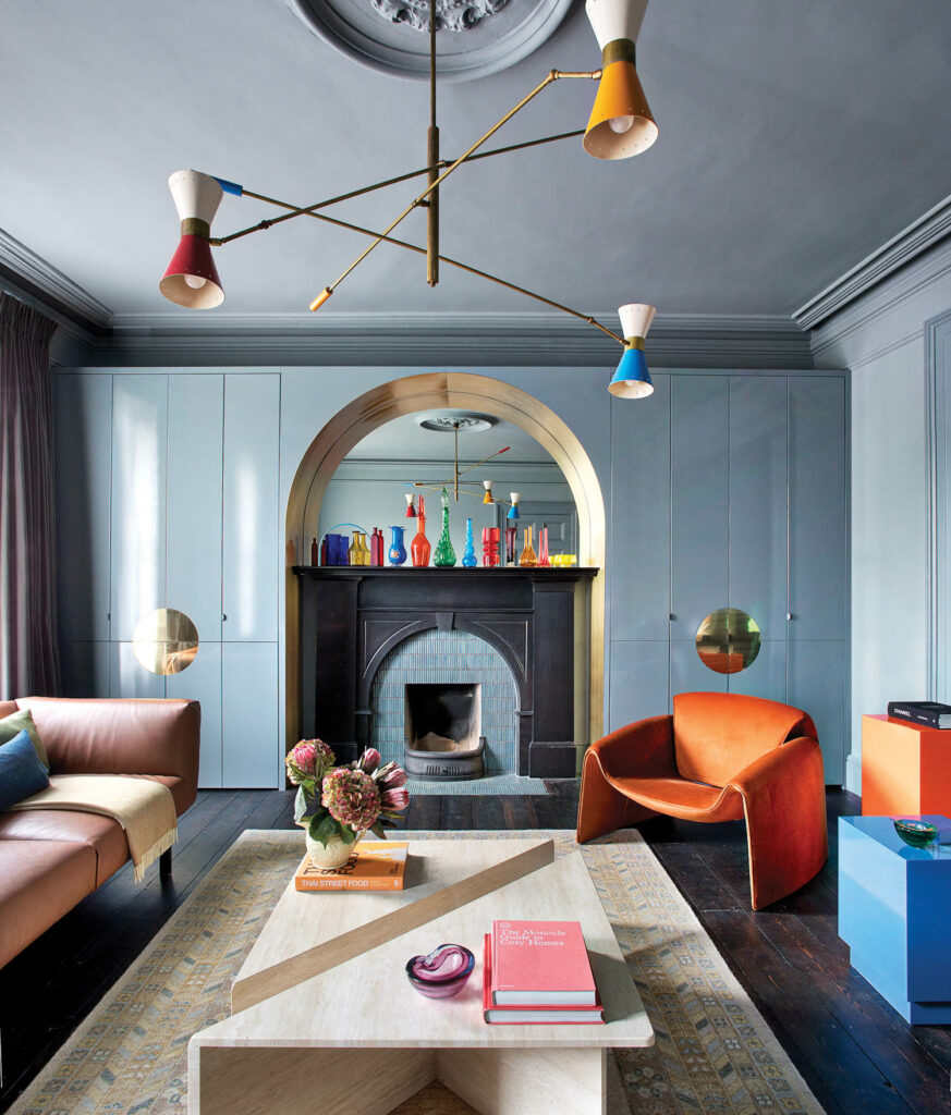 bright furniture accents blue built ins and a fireplace adorned with colorful vases