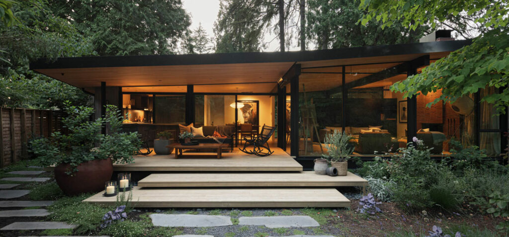 the exterior of a mid century home with concrete pavers and lush natural greenery