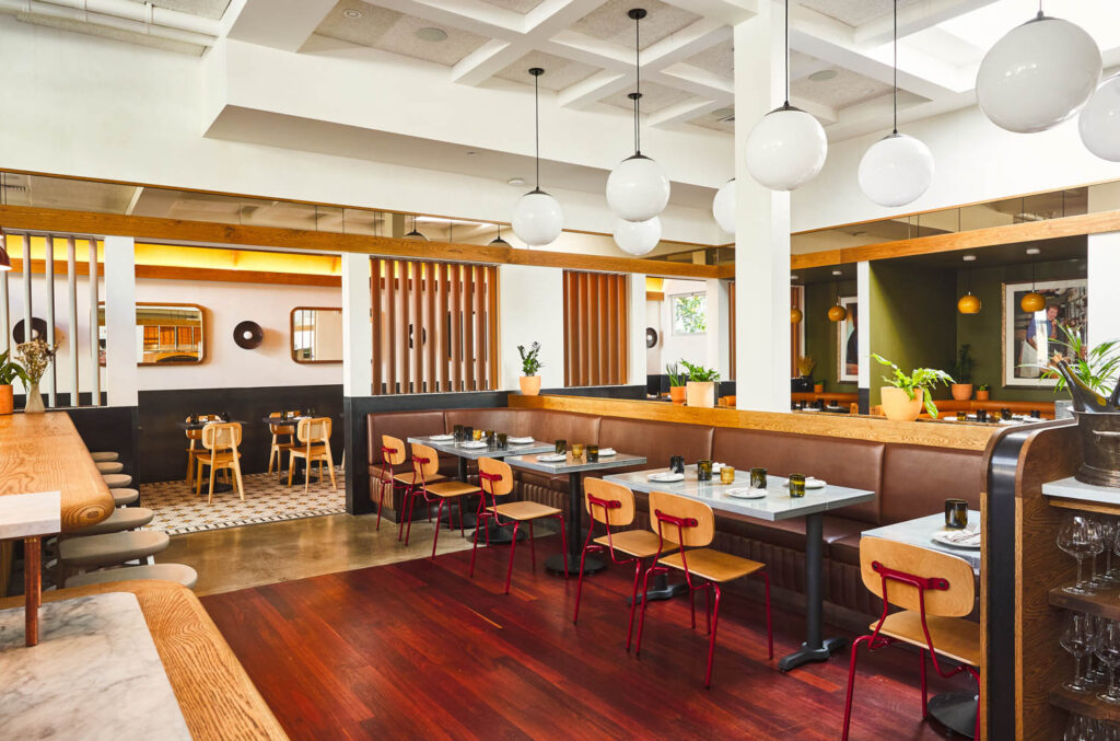 rows of white globe pendants hang over the dining area of a restaurant 