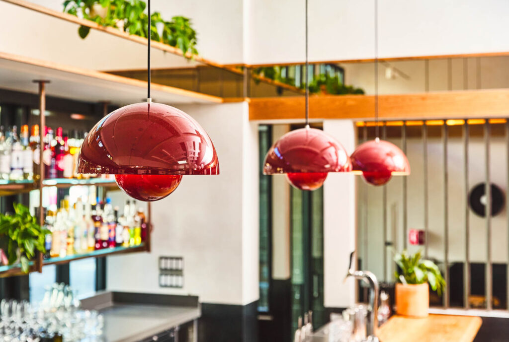 red pendant lights hanging above a bar