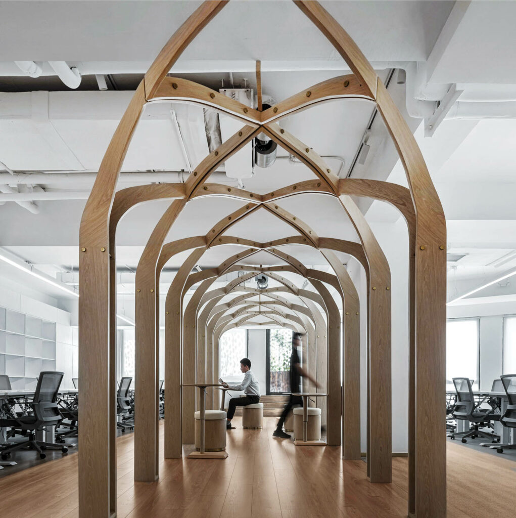 A wooden arch creates a focal point in the middle of this coworking space, enabling people to work within art.