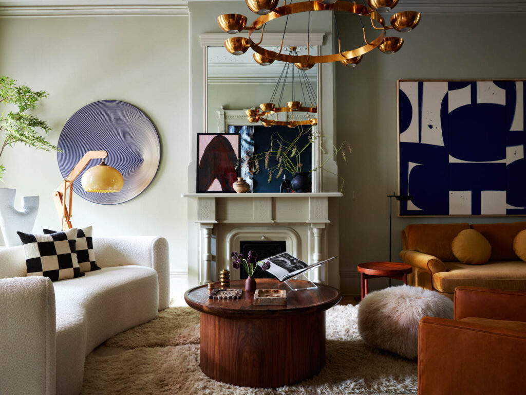 a living room in a brooklyn brownstone with a white sofa, yellow sofa, and a cozy rug underneath both