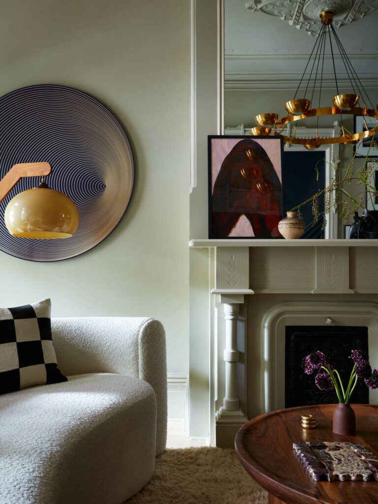 a living room of a Brooklyn home with a stately fireplace and abstract artwork