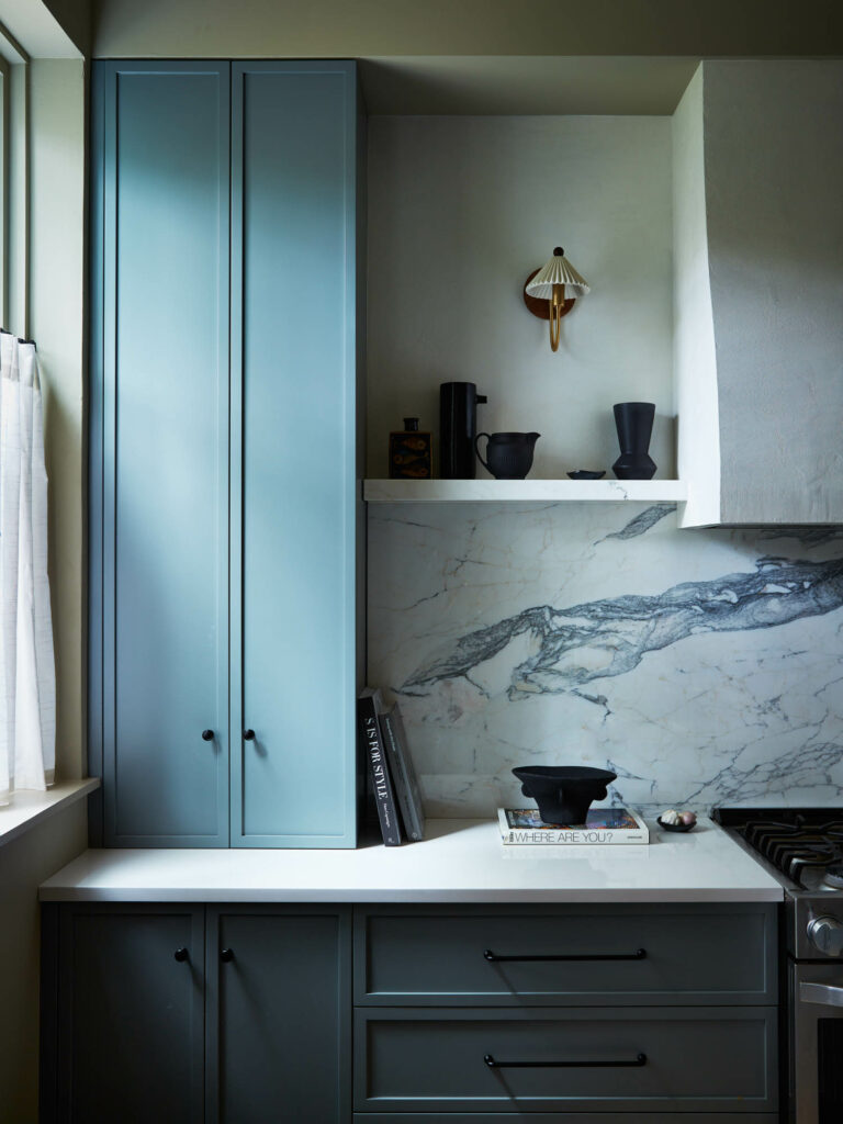 blue cabinets and a marble backsplash in the kitchen of a Brooklyn brownstone