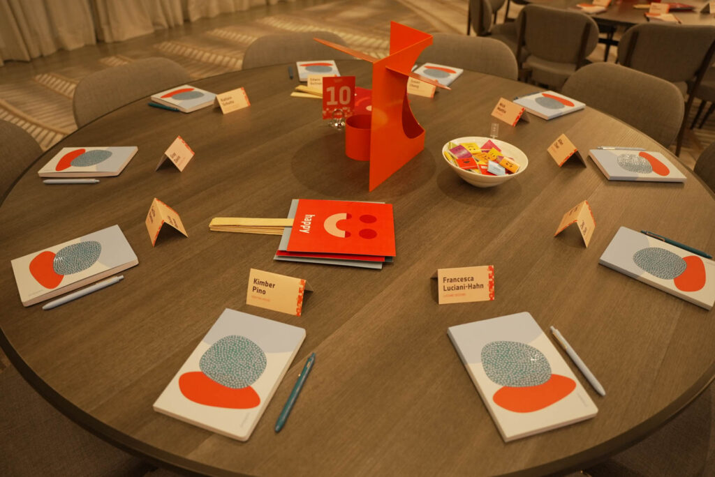 A table setting with a notebook and pens as well as emoji-themed signs