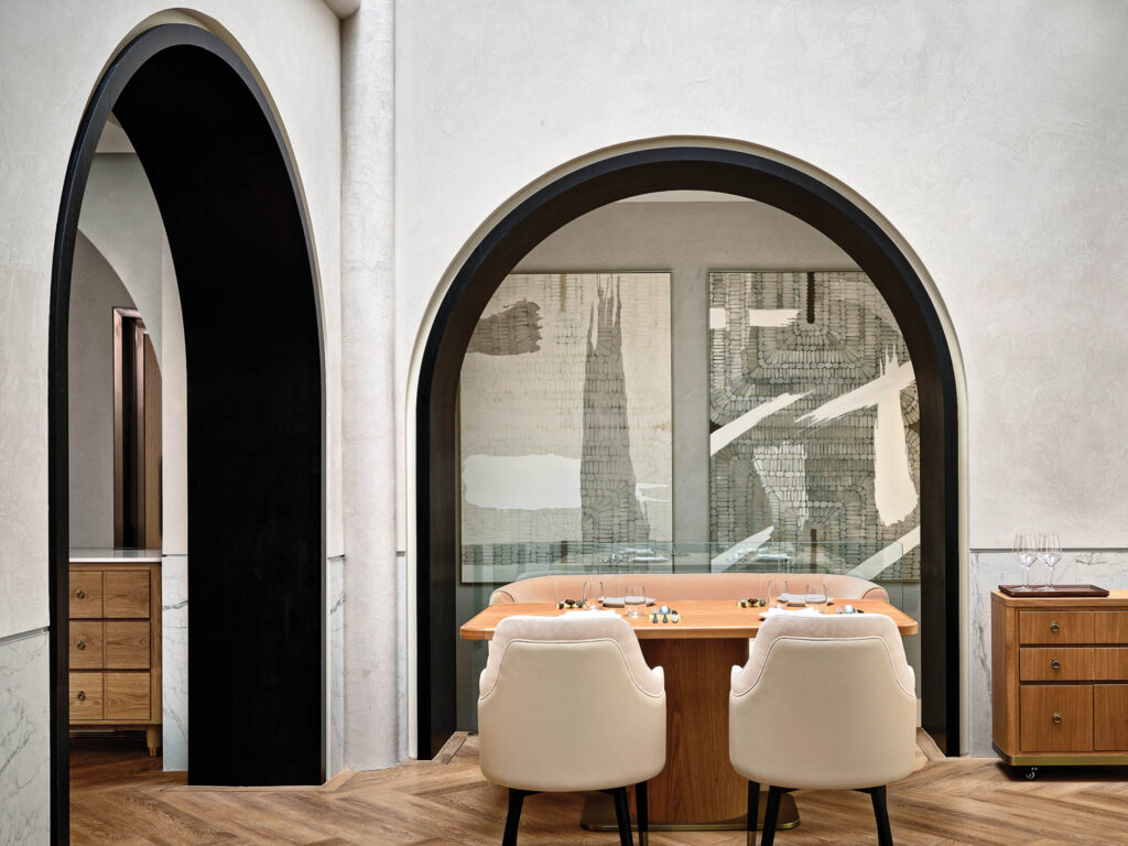 large oil canvases are seen through an arched niche in Restaurant Born