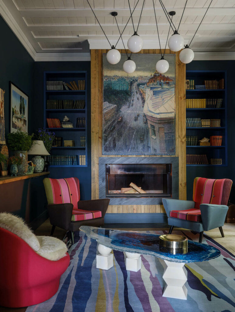 inside the home of Mia Karlova with blue built in shelves flanking a fireplace