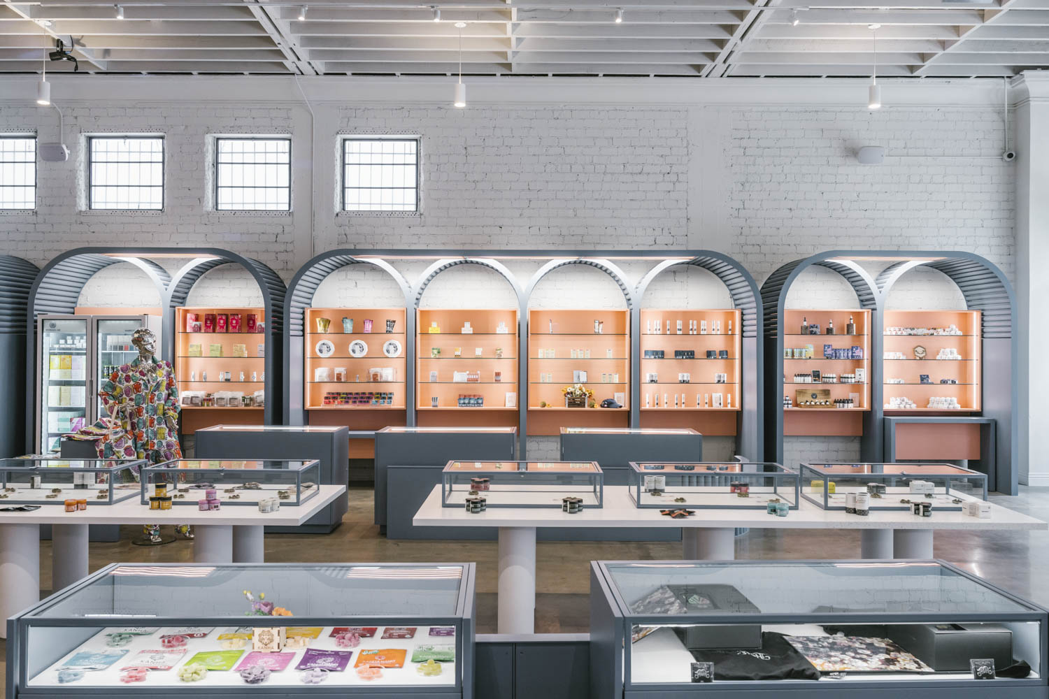 arched display shelves with orange backing in a dispensary shop