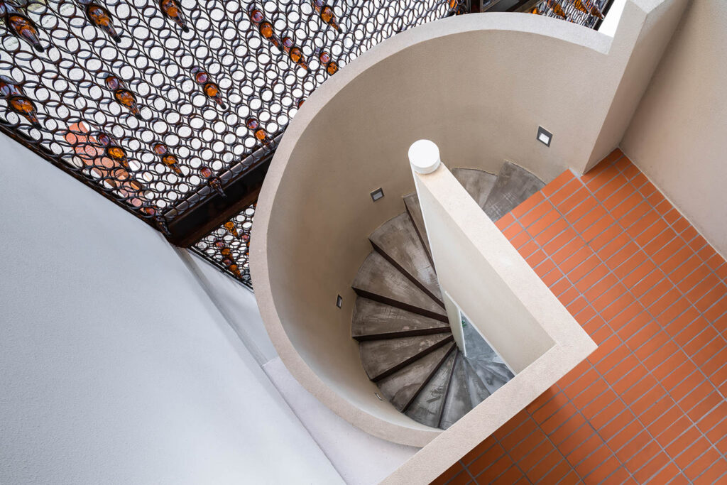 a spiral staircase leads to brick flooring in a cafe