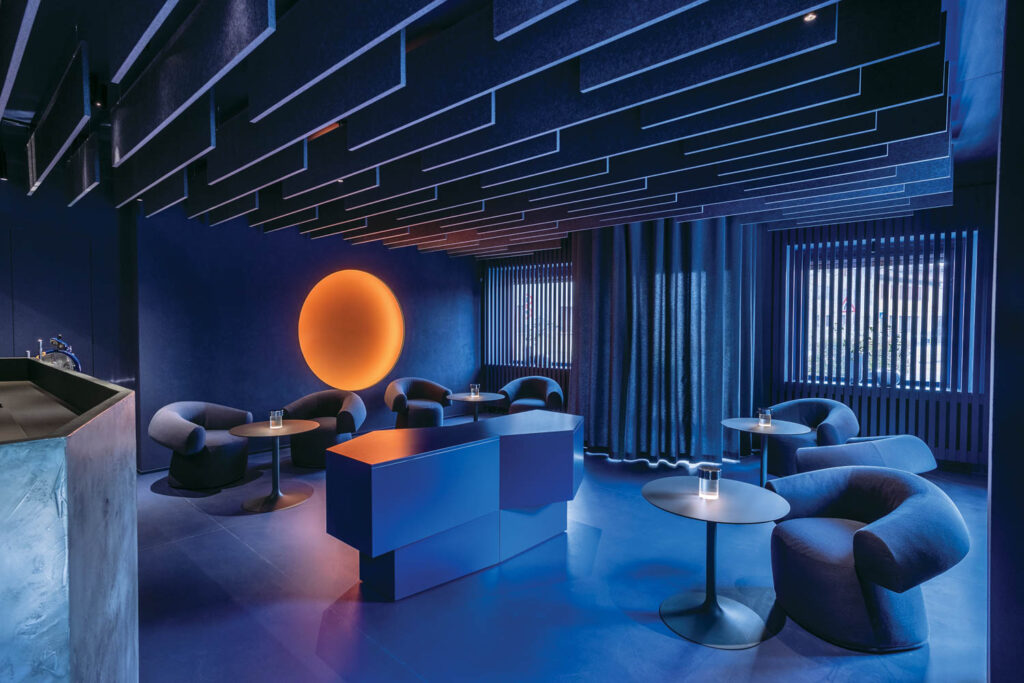 a deep-blue lounge with an installation that resembles the setting sun