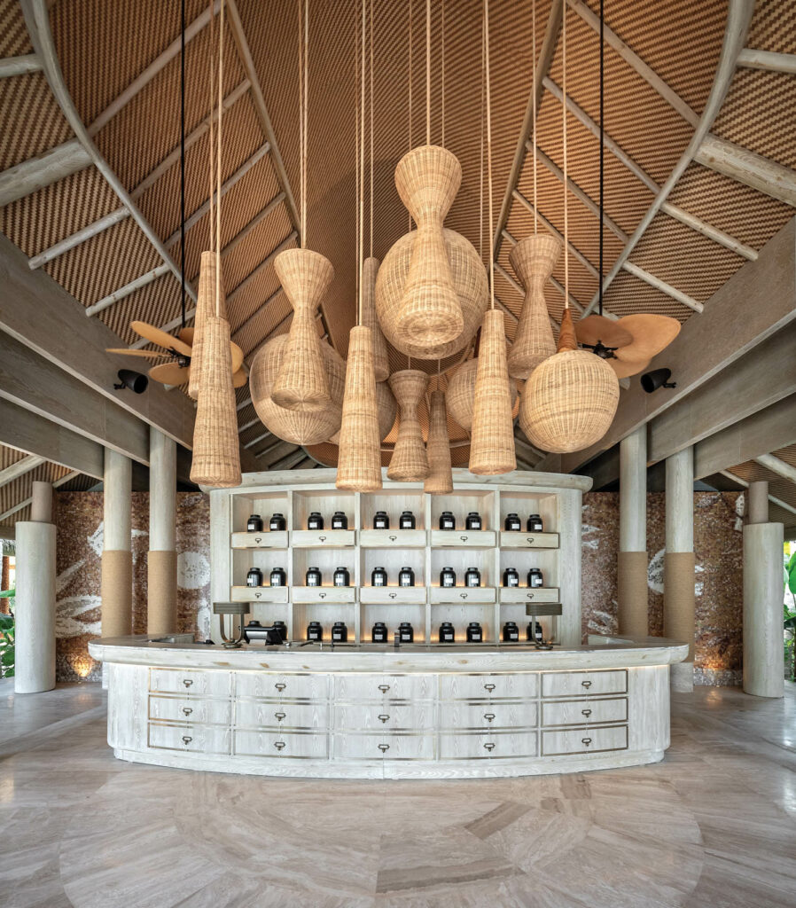 rattan pendant lights hang from the ceiling above a counter at Joali Being