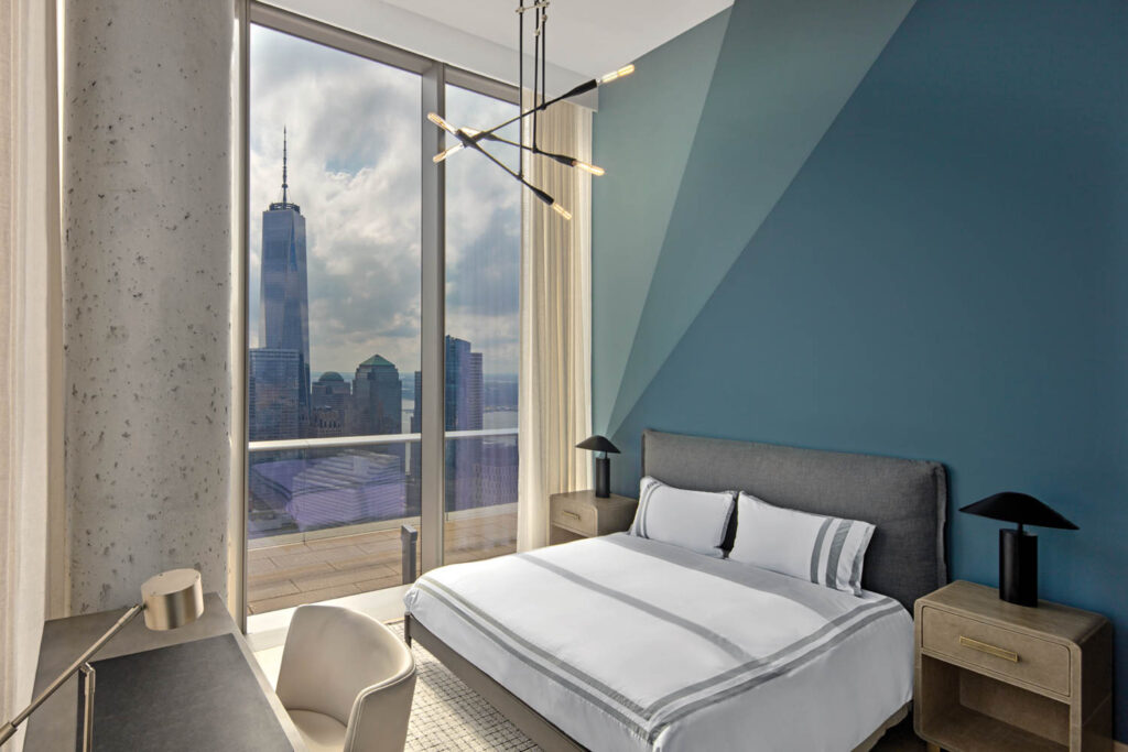 a bedroom in an apartment with an ombre blue wall